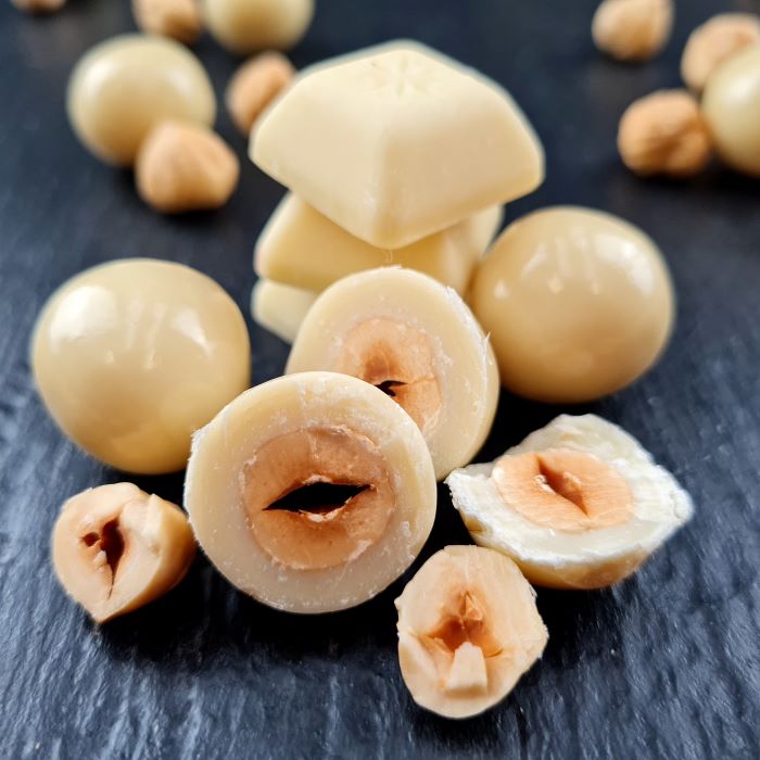 Dražejas ar lazdu riekstiem baltā beļģu šokolādē